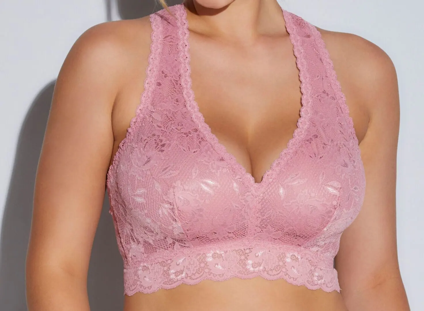 A woman wearing a pink lace bra.