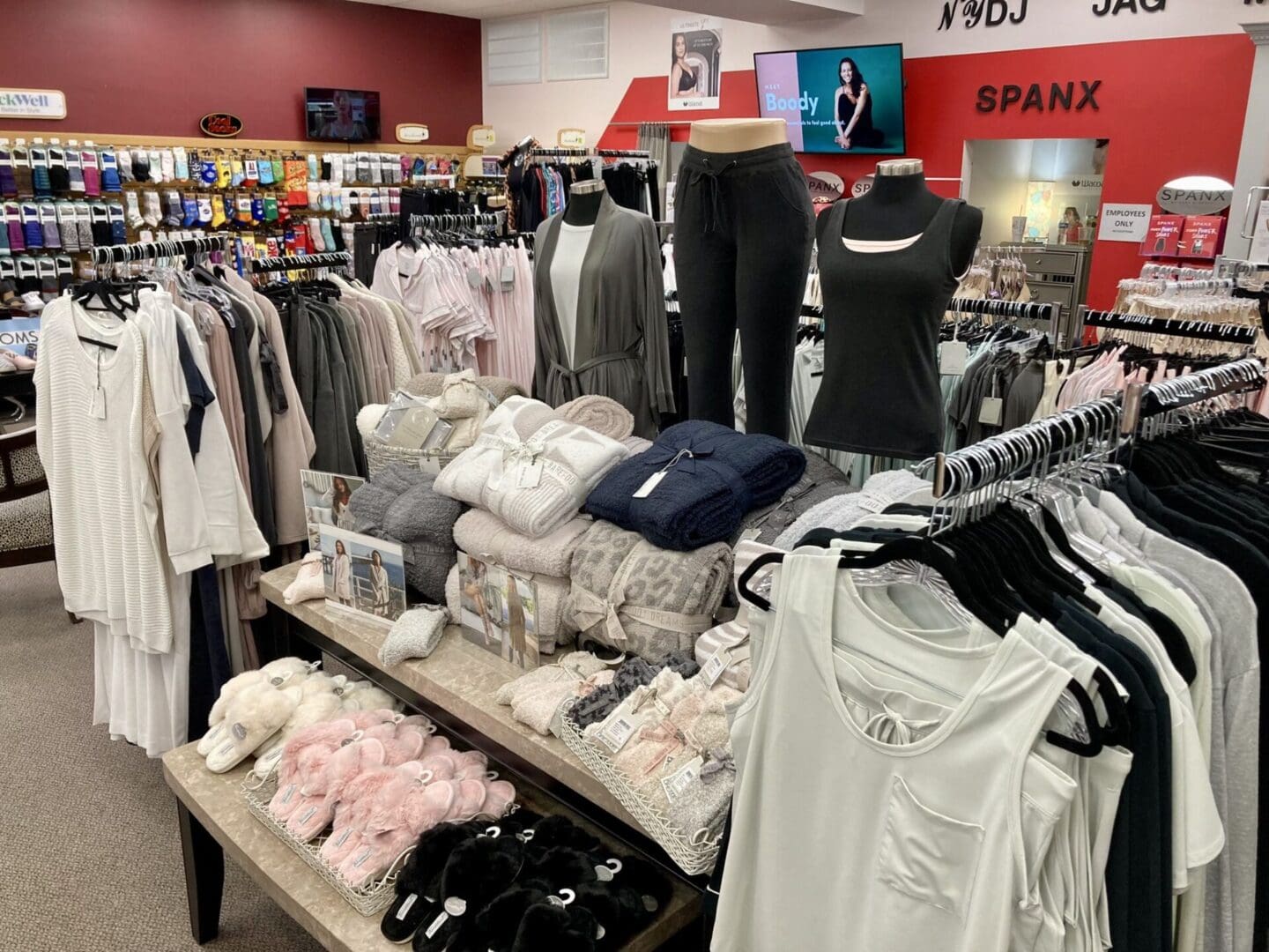 An array of women's clothing and accessories displayed in a retail store.